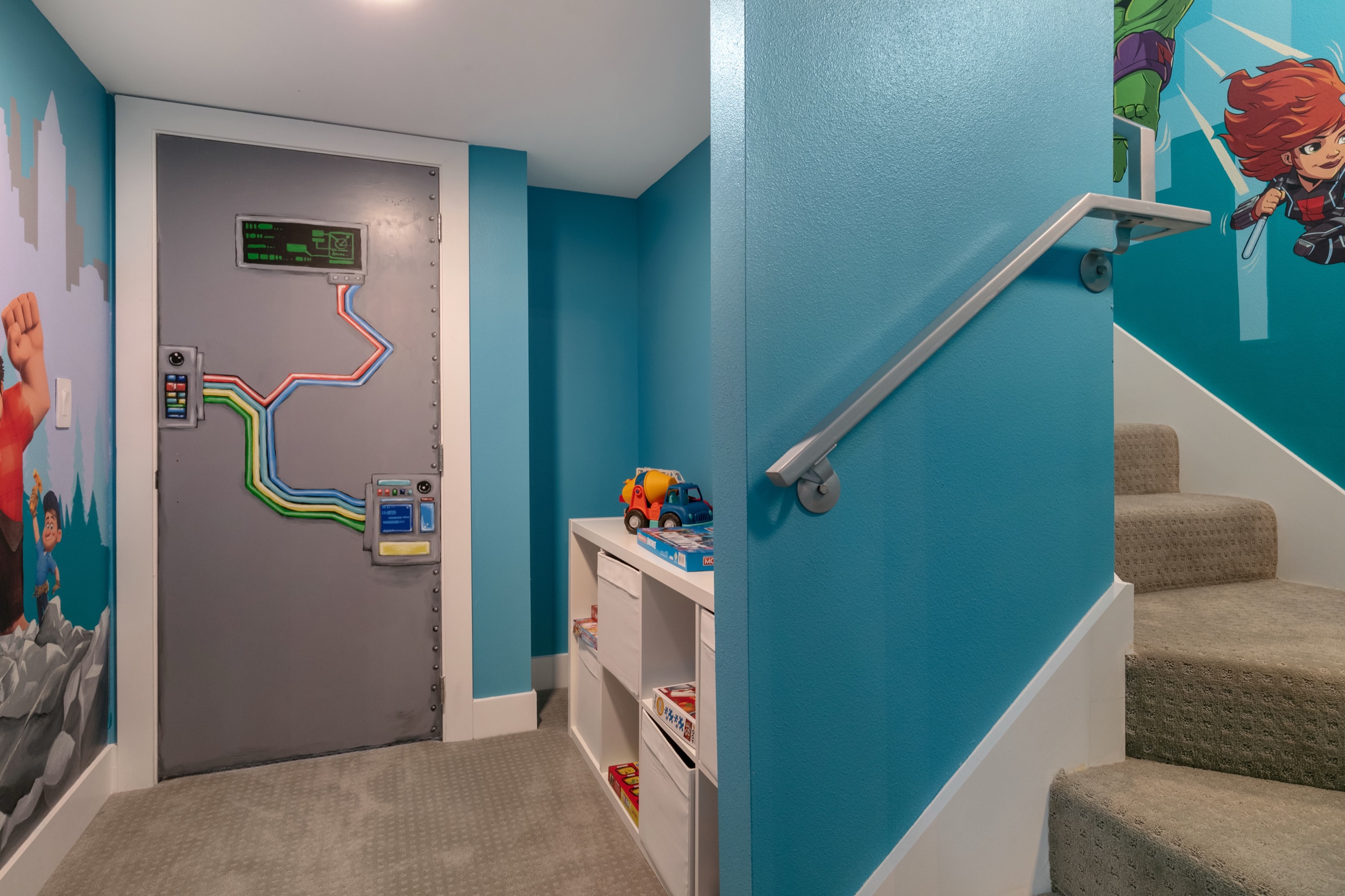 Hand-painted play nook with a circuit-panel door mural, character murals up the stair, and toy storage