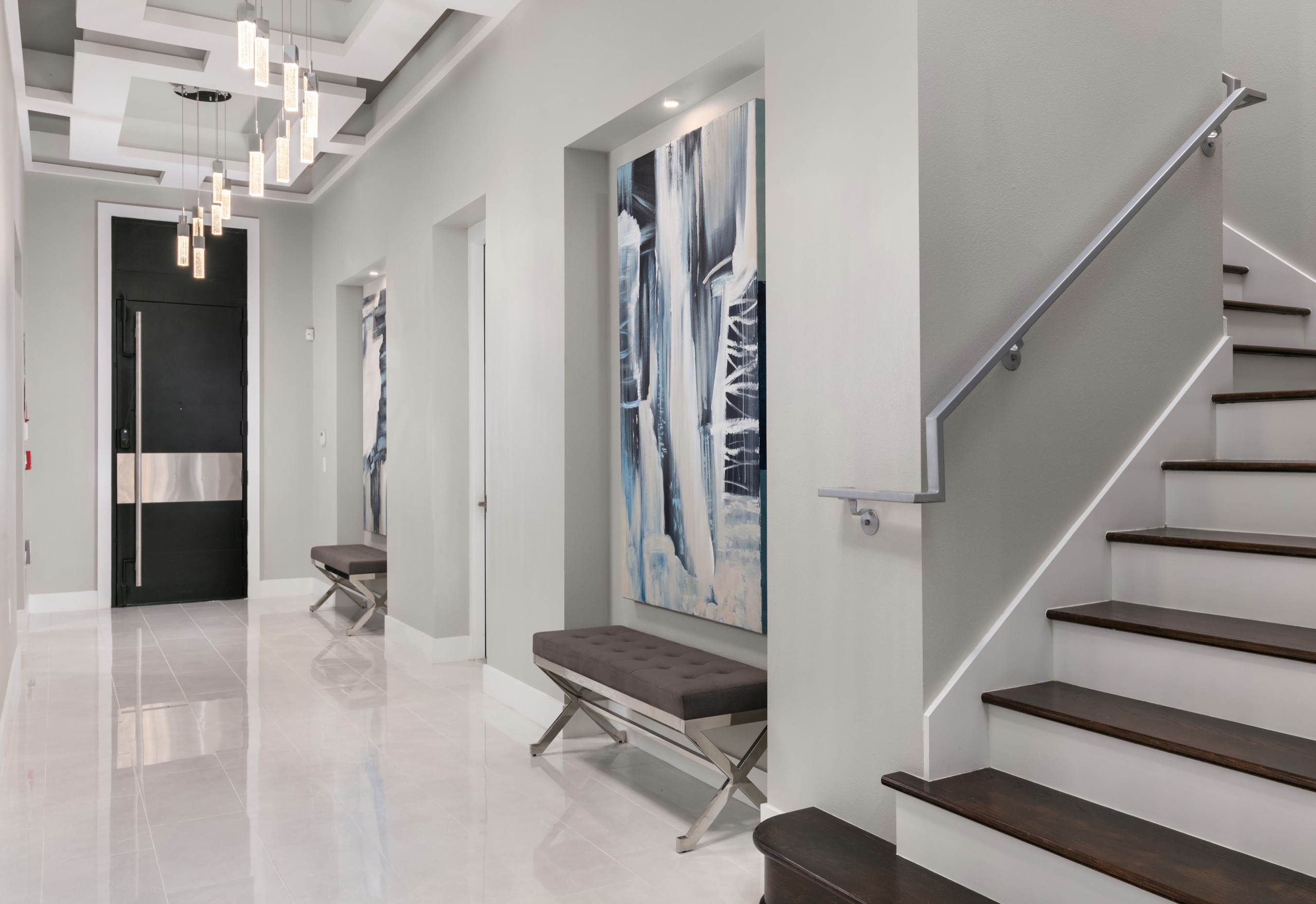 Gallery foyer lined with large abstract canvases and the open stair