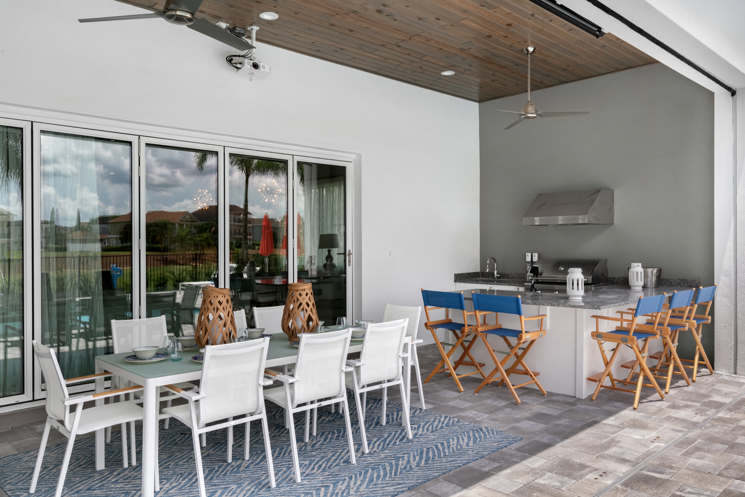 Covered lanai with a summer kitchen and dining overlooking the pool