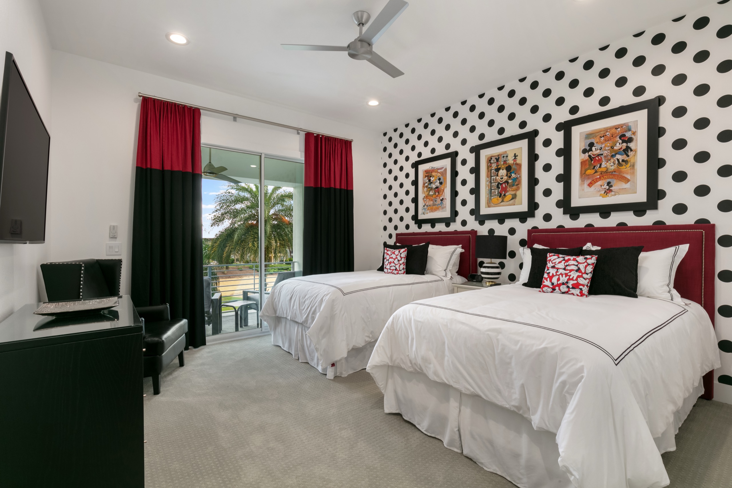 Mouse-themed suite with twin red-headboard beds and a black-and-white polka-dot accent wall