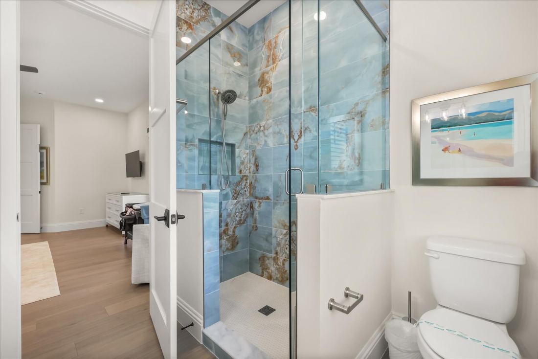 Spa shower in glass with a floor-to-ceiling coastal mural