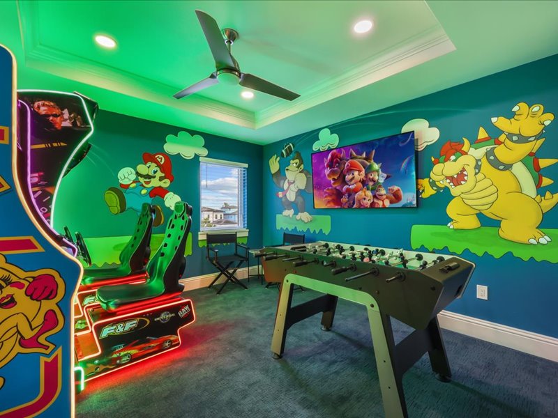 Neon-lit arcade with classic machines and a Mario mural