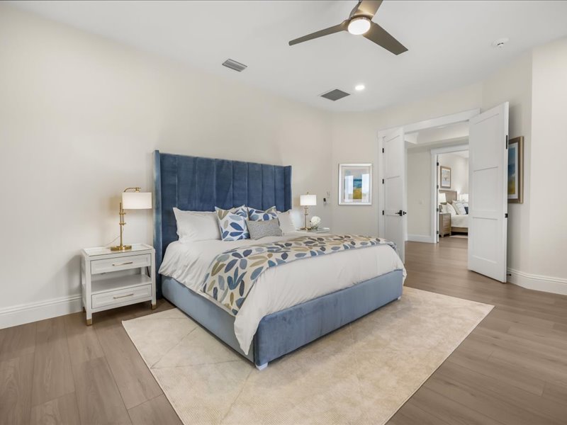 Second guest suite with a blue velvet headboard and patterned bedding