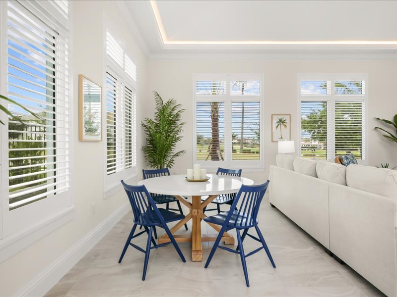Breakfast nook with blue chairs beside a wall of windows