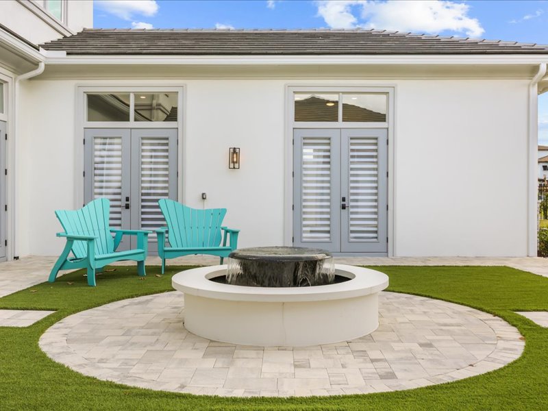 The courtyard's bubbling stone fountain framed by teal Adirondack chairs