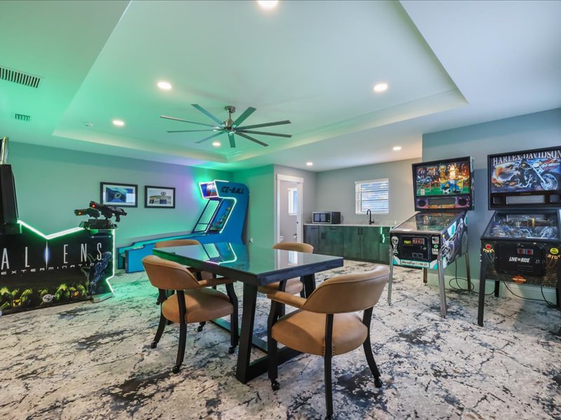 Game floor with a dining table set among arcade machines and neon