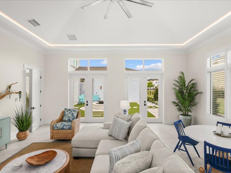 Living room opening through glass to the courtyard and pool
