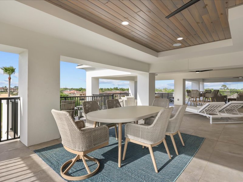Covered terrace dining set beneath a wood ceiling