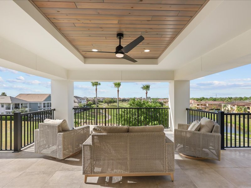 Covered loggia lounge under a wood ceiling overlooking the course