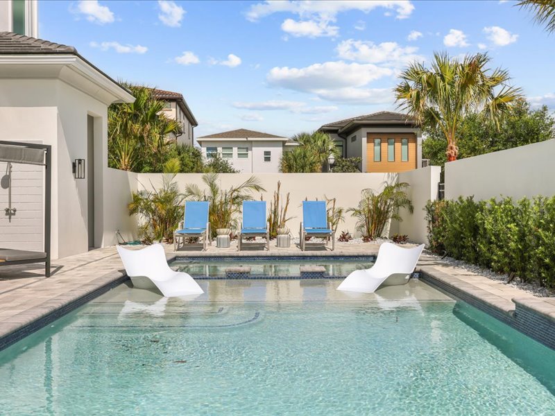 The resort pool set in travertine beside the covered lanai