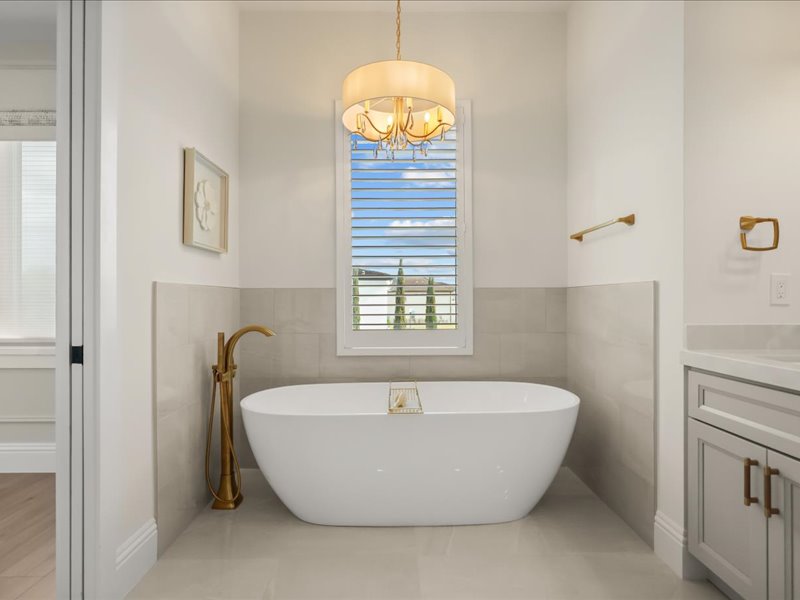 Primary bath with a freestanding soaking tub and gold fittings